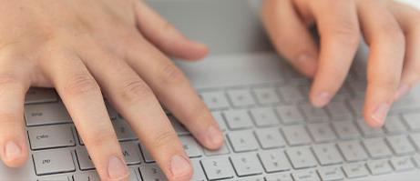 student typing on laptop